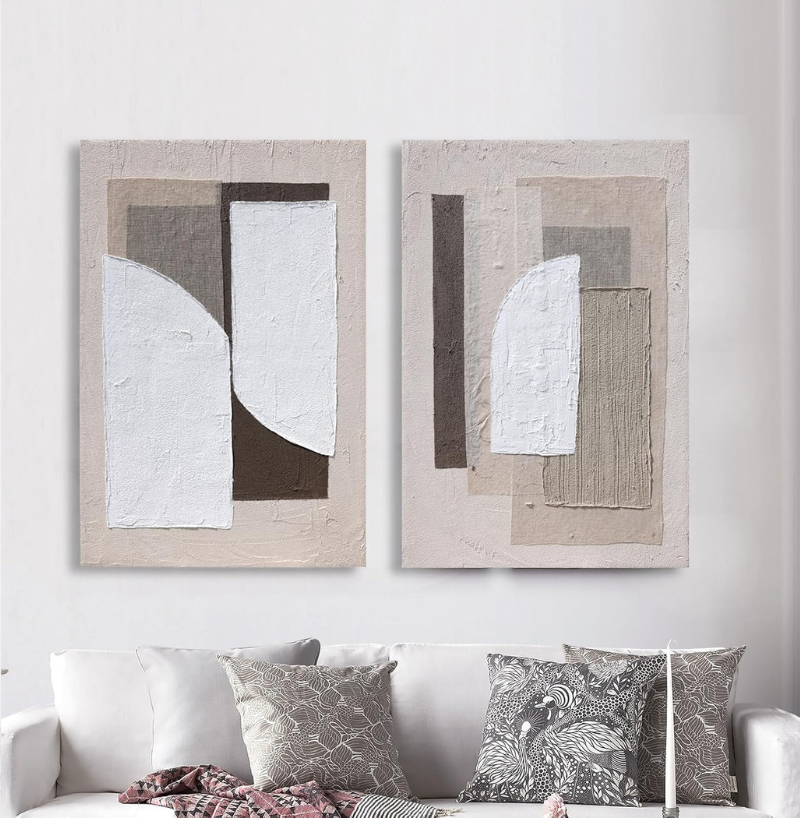 Neutral abstract art displayed above a modern sofa in a bright living room